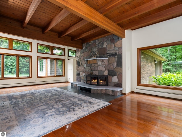 unfurnished living room featuring beam ceiling, a fireplace, wood ceiling, and baseboard heating