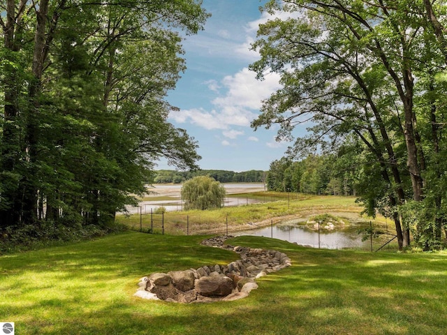 surrounding community featuring a water view and a yard