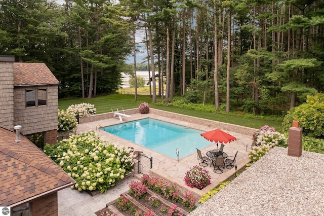 view of swimming pool with a yard, a diving board, and a patio area