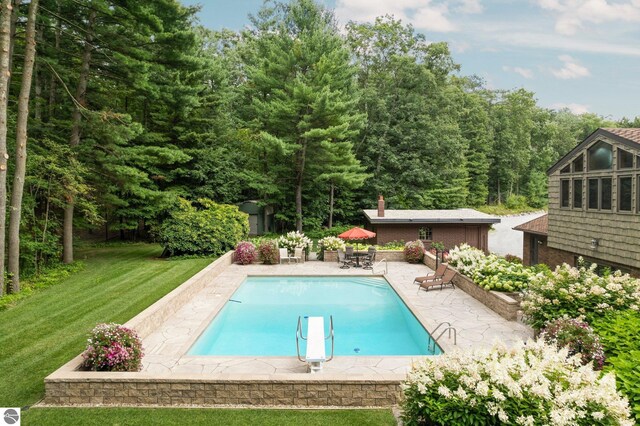 view of pool featuring a lawn and a patio area