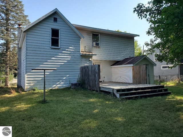 back of property featuring a yard, a wooden deck, and a storage unit