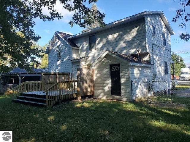 back of property with a yard and a deck