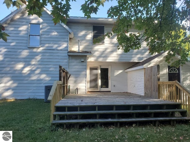 rear view of property with a yard and a wooden deck