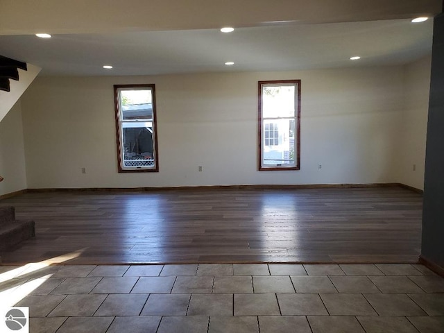 empty room with dark wood-type flooring and plenty of natural light