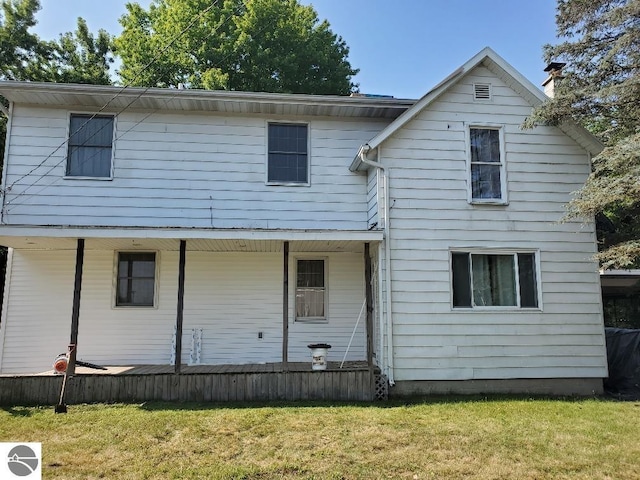 back of property featuring a lawn