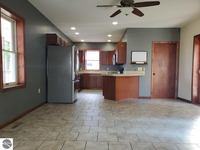 kitchen with stainless steel appliances, kitchen peninsula, light tile patterned floors, and ceiling fan