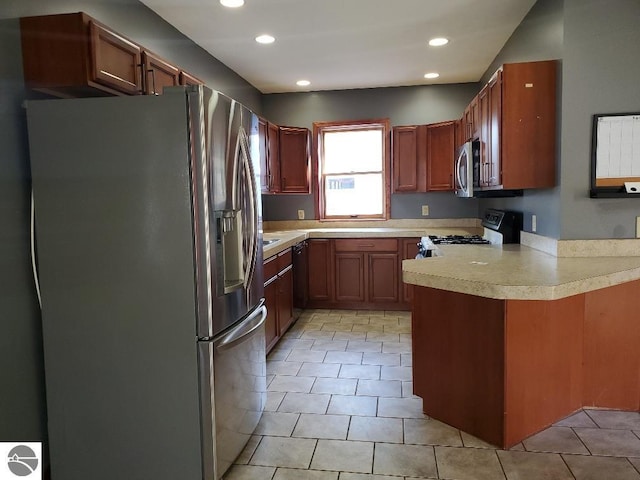 kitchen featuring appliances with stainless steel finishes, kitchen peninsula, and light tile patterned floors