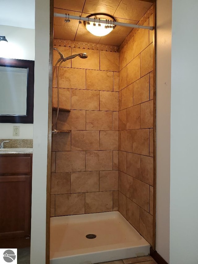 bathroom with vanity and tiled shower