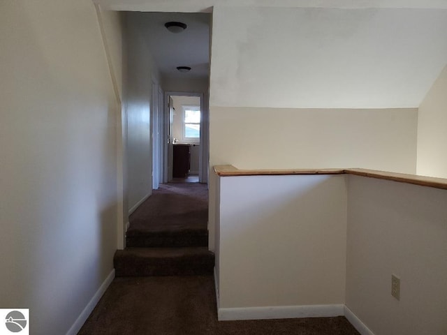 hallway featuring dark colored carpet