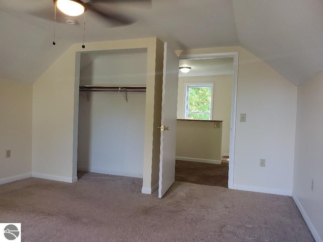 unfurnished bedroom featuring ceiling fan, lofted ceiling, a closet, and carpet