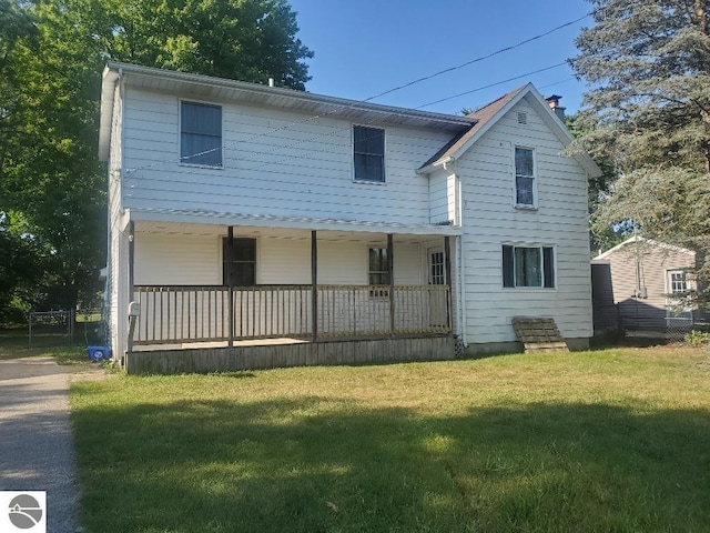 back of property with a porch and a yard