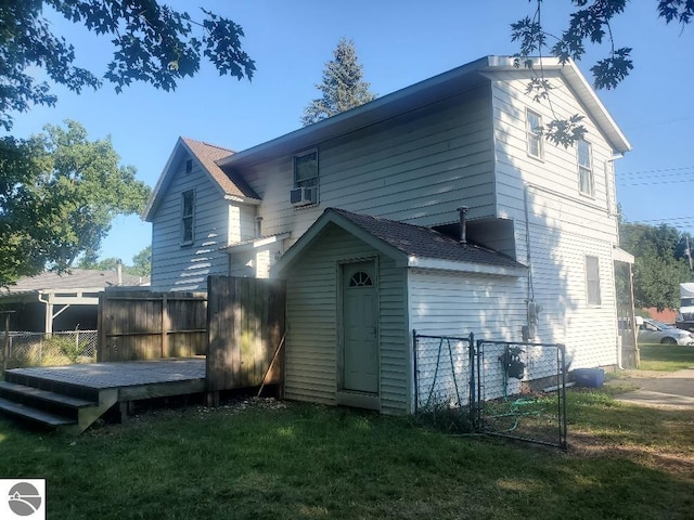 back of property featuring cooling unit, a deck, and a lawn