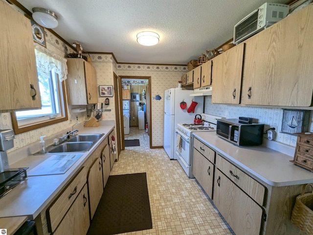 kitchen featuring light tile patterned flooring, white appliances, sink, and a textured ceiling