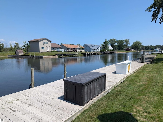 view of dock with a water view and a lawn