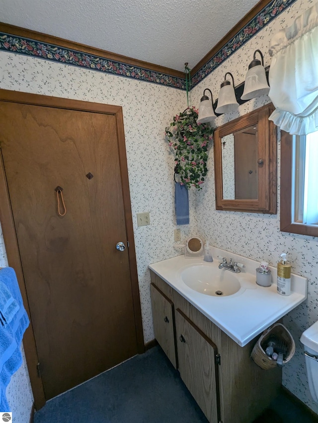 bathroom featuring toilet, vanity, and a textured ceiling