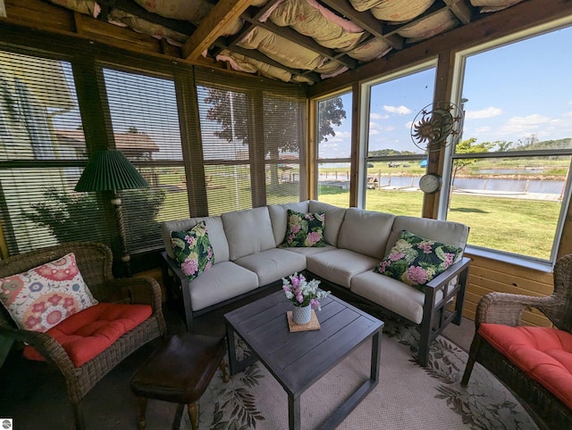 sunroom featuring a water view