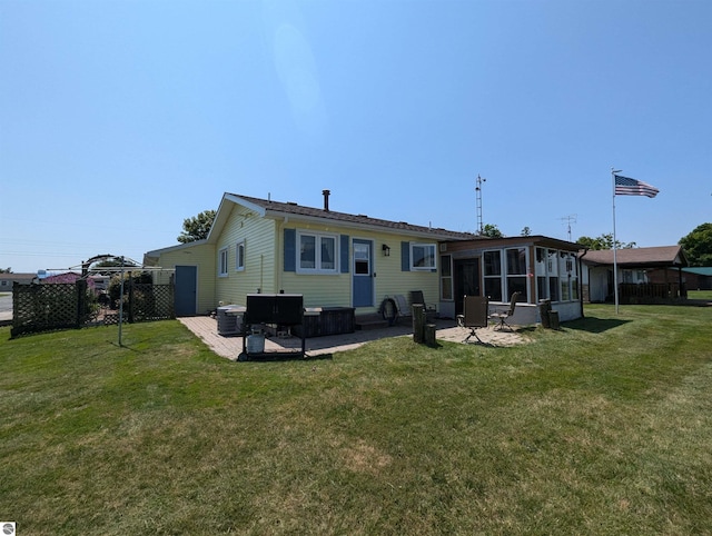 back of property with a lawn and a patio area