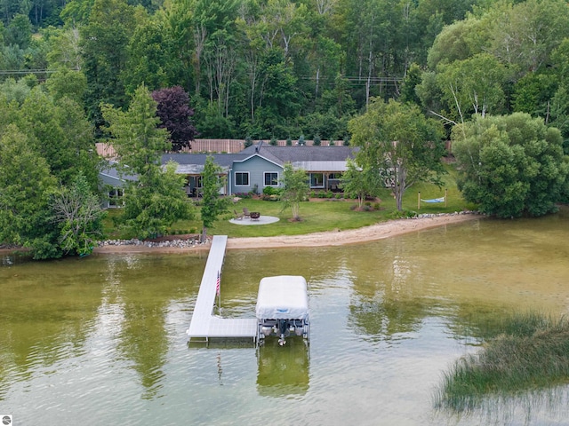 view of dock with a yard and a water view