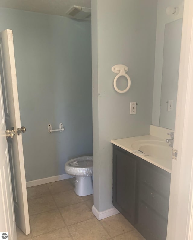 bathroom with toilet, tile patterned flooring, and vanity