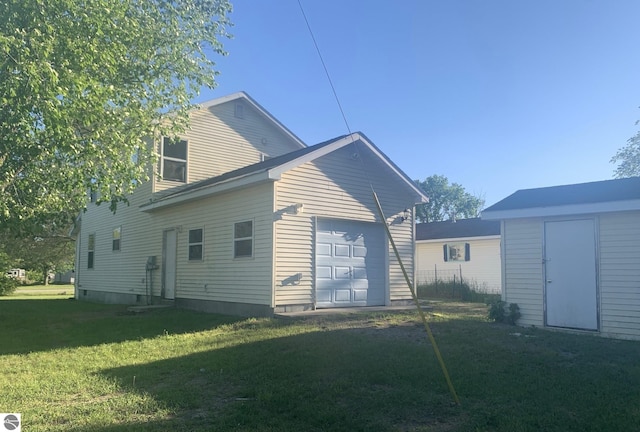 back of house featuring a yard and an outdoor structure