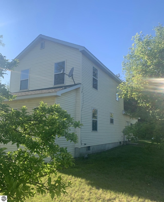 view of side of home with a lawn