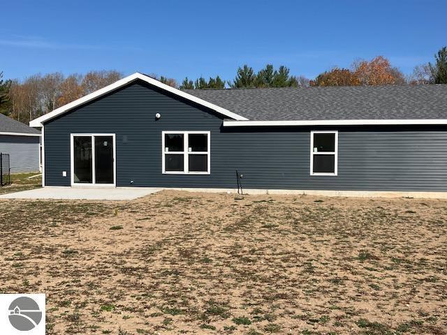 back of property featuring a patio area and a lawn