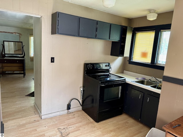 kitchen featuring light wood-type flooring, electric range, wooden walls, and sink