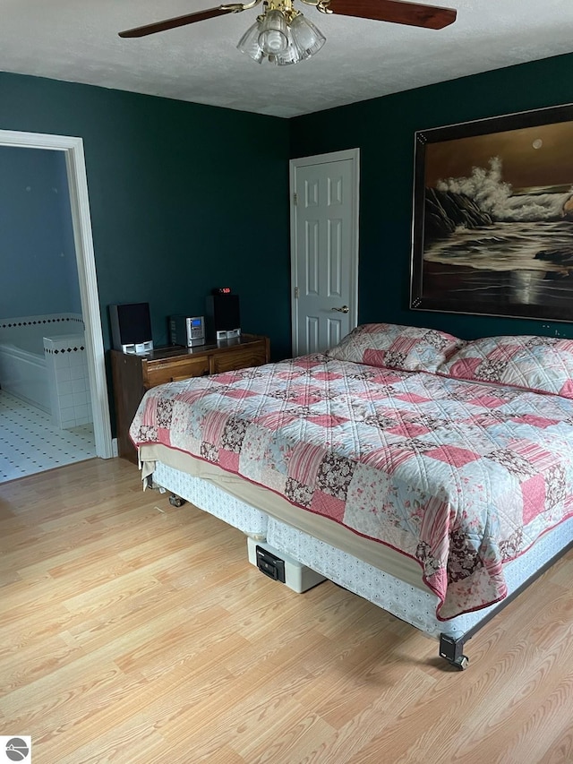 tiled bedroom featuring ceiling fan and connected bathroom