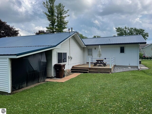 rear view of house featuring a deck and a lawn