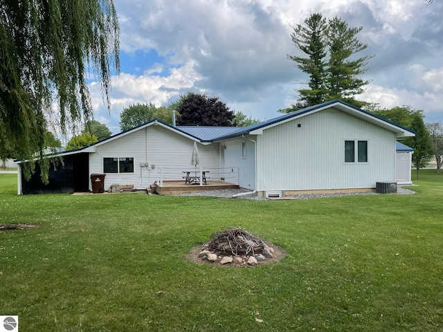 rear view of property with a patio area, central AC unit, and a yard