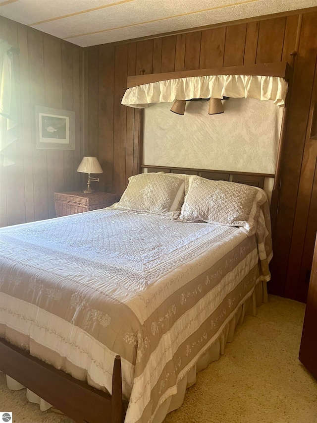 carpeted bedroom featuring wood walls