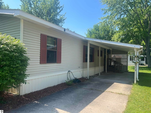 view of side of property featuring a yard and a carport