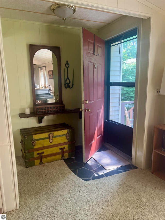 carpeted foyer featuring a textured ceiling