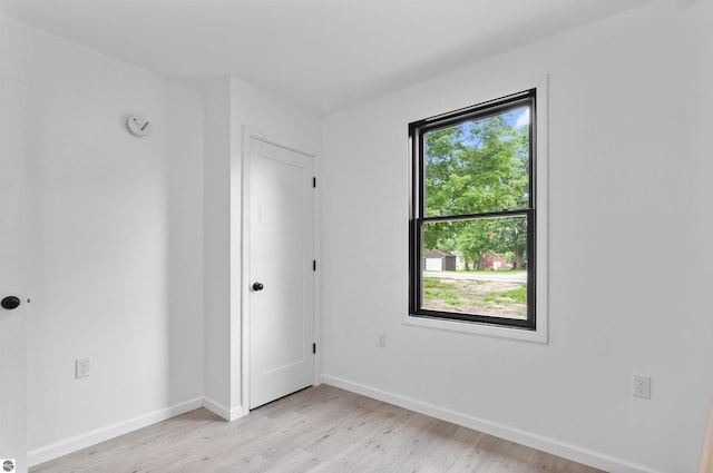 spare room featuring light hardwood / wood-style floors and plenty of natural light