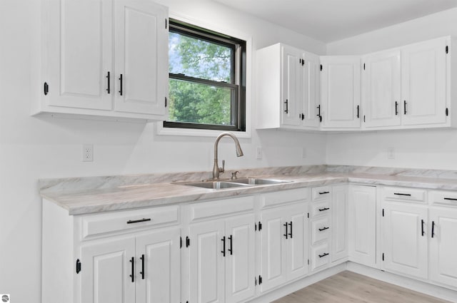 kitchen featuring sink, light hardwood / wood-style flooring, and white cabinetry