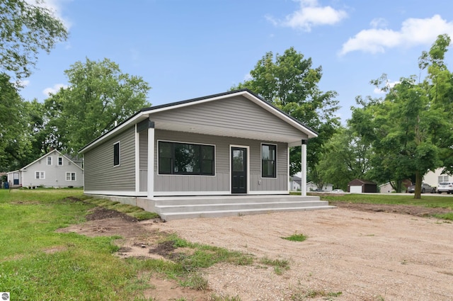 view of front of house with covered porch and a front lawn