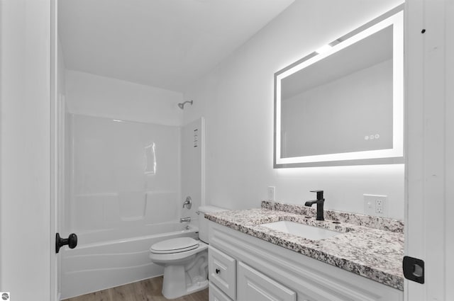 full bathroom with shower / washtub combination, hardwood / wood-style floors, vanity, and toilet