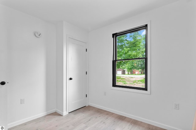 spare room featuring light wood-type flooring and a healthy amount of sunlight