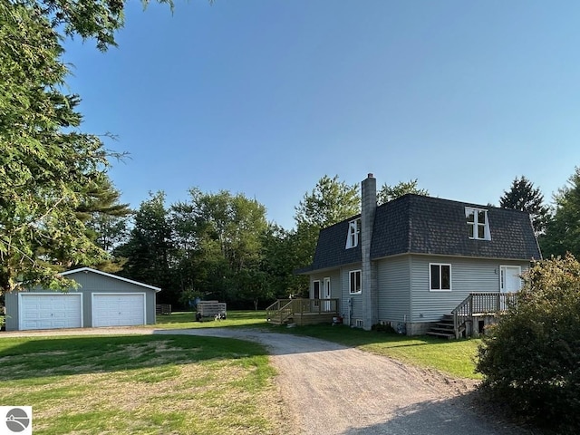 view of property exterior featuring a garage, a yard, and an outbuilding