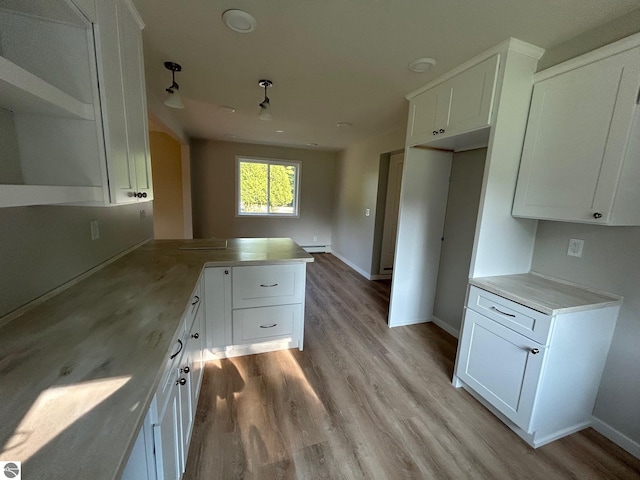 kitchen featuring a baseboard heating unit, white cabinets, and light hardwood / wood-style floors