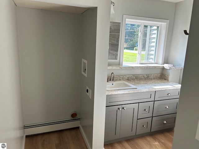 bathroom featuring vanity, baseboard heating, and hardwood / wood-style flooring