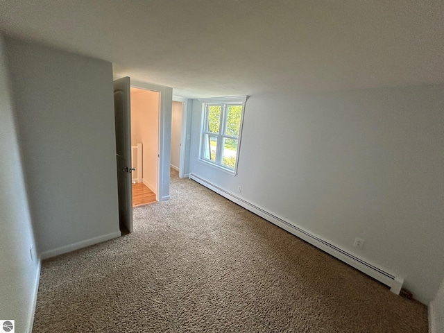 carpeted spare room featuring a baseboard radiator