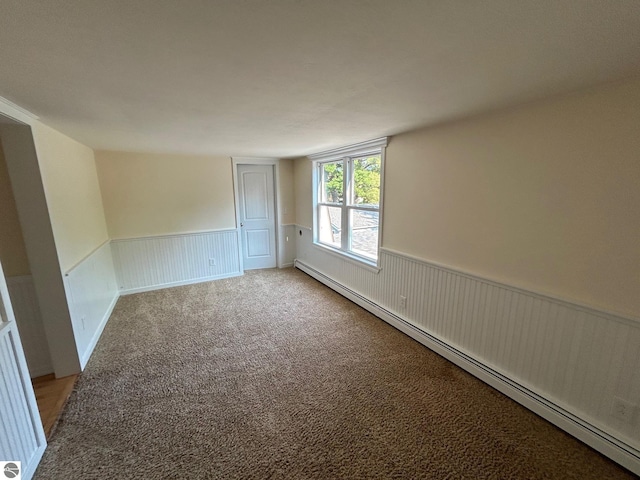 carpeted spare room with a baseboard radiator