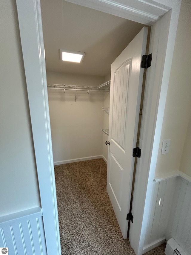 walk in closet with carpet and a baseboard radiator