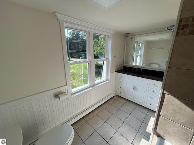 bathroom featuring plenty of natural light, vanity, tile patterned flooring, and toilet