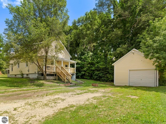 view of yard featuring an outbuilding, a porch, and a garage