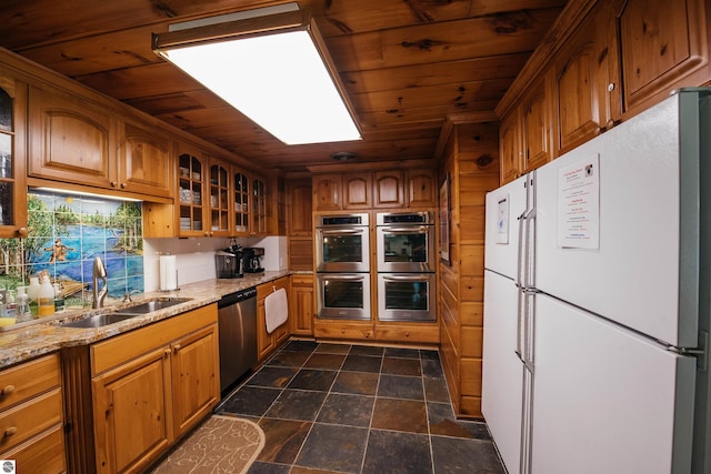 kitchen featuring dark tile patterned floors, appliances with stainless steel finishes, sink, and wooden ceiling