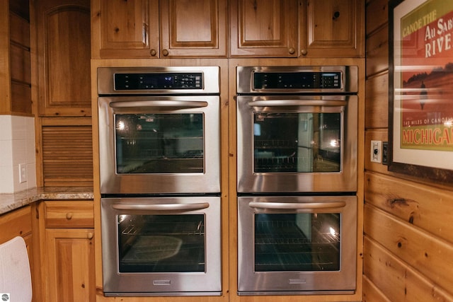 kitchen featuring light stone counters and double oven