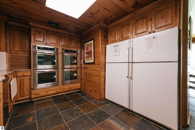 kitchen with double oven, wooden ceiling, and dark tile patterned flooring