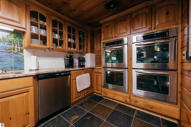 kitchen featuring dark tile patterned floors, stainless steel appliances, light stone counters, decorative backsplash, and wooden ceiling